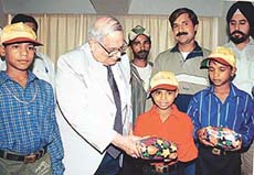 The Punjab Governor and UT Administrator, Lieut Gen J.F.R. Jacob (retd), presents gift packs to shoeshine boys before seeing them off to Solan from the UT Secretariat, Sector 9, Chandigarh, on Thursday.