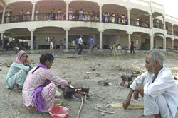 A displaced family cooking their meal at a migrant camp