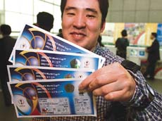 Japanese office worker Satoru Ogura smiles upon receiving tickets for the World Cup applied for through the Internet at a FIFA ticketing kiosk counter in Tokyo.