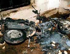 A burnt motorcycle, which was set on fire by a violent mob, lies in the Zuhapura area