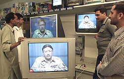 Pakistanis watch a televised speech