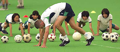 Ireland striker Niall Quinn practices stretching with local children prior to training in the Izumo dome on Wednesday. Ireland's group E opponents include Germany, Saudi Arabia and Cameroon.