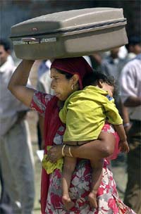 An Indian refugee carries her belonging