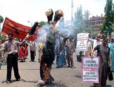 Bhopal gas affected persons burn a two-mouth effigy