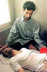 An unidentified relative sits besides a victim