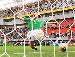 Ireland's Gary Kelly lunges for the ball as it crosses the line for a goal by Cameroon's Patrick Mboma (not pictured) during their first round match at the World Cup finals in Niigata Stadium on Saturday. 