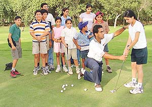 Ajay Gujral teaches golf techniques to youngsters at the Chandigarh Golf Club on Tuesday.