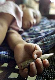 Babloo, 2, a migrant boy from Garkhaal village, sleeps at a refugee camp
