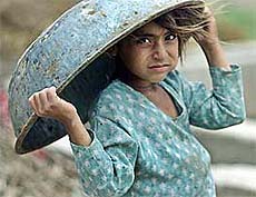 Eight-year-old migrant Mira covers her head