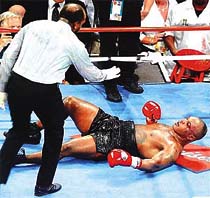 Referee Eddie Cotton gives Mike Tyson a count