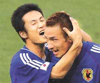 Japans Hidetoshi Nakata is hugged by team-mate