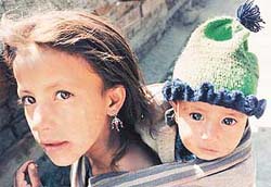 A mountain lass carries an infant