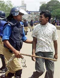 A Bangladeshi policeman grabs an Opposition activist