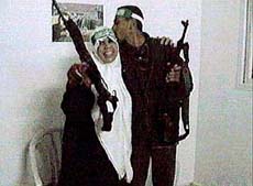 With a smile on her face and an assault rifle in her hand, Naima al-A'abed bids farewell to her son