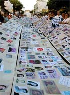 Antiglobalization activists carry a huge banner with thousands of photographs of antiglobalisation supporters 