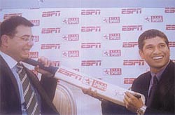 Sachin Tendulkar autographs a bat for Manu Sawhney of ESPN Star Sports