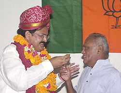 Newly elected BJP President M. Venkaiah Naidu offers sweet to former BJP President