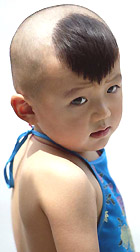 A Chinese boy sports a Ronaldo hairstyle as he wears a traditional Chinese undergarment during a family outing in Beijing on Tuesday. 