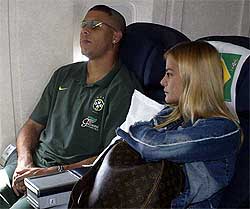 Brazilian striker Ronaldo and his wife Milene take a break during the team's return flight to Brazil