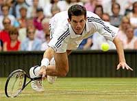 Britain's Tim Henman stumbles as he returns the ball to Brazil's Andre Sa 