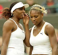 Venus and Serena Williams of the USA confer during their women's doubles match
