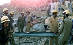 Kashmiri rescue workers carry a stretcher