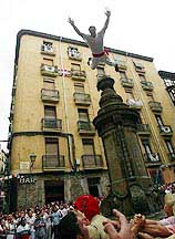 A San Fermin reveller dives off the "Navarreria" fountain