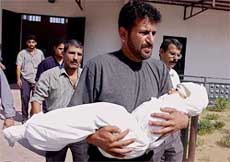 Zakaria Hindi carries the body of his 2-year-old niece Noor