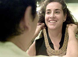 An attendant at a jewellery stall assists Laura Marsical