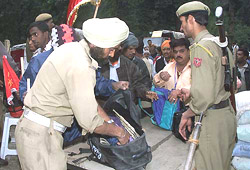 Security personnel check the belongings of pilgrims