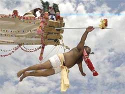 A man is paraded while suspended with hooks through his skin 