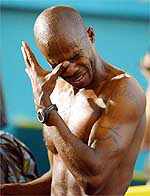 Kim Collins of St Kitts and Nevis wipes his eye after winning gold in the men's 100m 