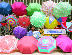 Subhodh Pal Gupta, 20, an Indian umbrella seller, sets his umbrellas up for sale