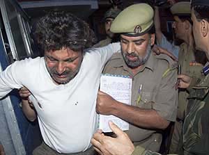 Policemen help an injured pilgrim