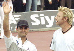 Indian actor Aamir Khan, with German tennis star Boris Becker, waves to the crowd