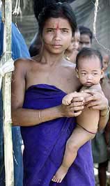A Bodo tribal woman waits for food in front of a makeshift relief camp
