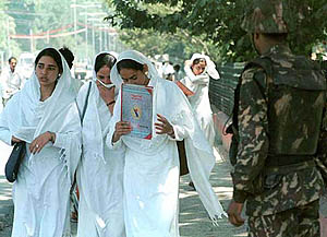 College girls walk past a BSF jawan