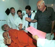 Chief Minister Farooq Abdullah talks to an injured pilgrim in a hospital at Pahalgam.