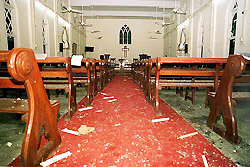 Shattered glass and other debris are littered on the floor of the church 