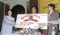 Union Health Minister Shatrughan Sinha presents the Shankha Pushpi Scholarship award.