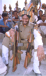 A fully loaded jawan of the ITBP smiles as he takes care of four rifles