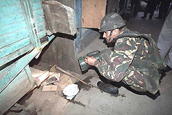 A paramilitary jawan searches for explosives