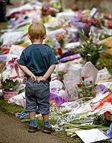 A young boy looks at flowers laid for the missing ten-year-old schoolgirls