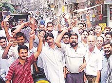 Members of the Ludhiana Hosiery Association protest against the government at the Madhopuri chowk in Ludhiana On Tuesday.