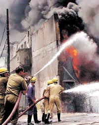 Firemen trying to control a major fire which engulfed a kerosene depot in Ali village