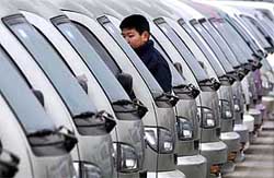 A potential car buyer tours a car market of locally-made vehicles