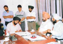 Vigilance Bureau officials examine documents while the three Municipal Council employees