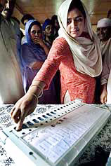 A Kashmiri woman tests an electronic voting machine