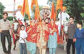 Devotees watch a tableau depicting life of Lord Krishna while participating in a shobha yatra