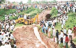 A JCB machine makes a futile attempt to drain out water from a pond from which bodies of three drowned youths